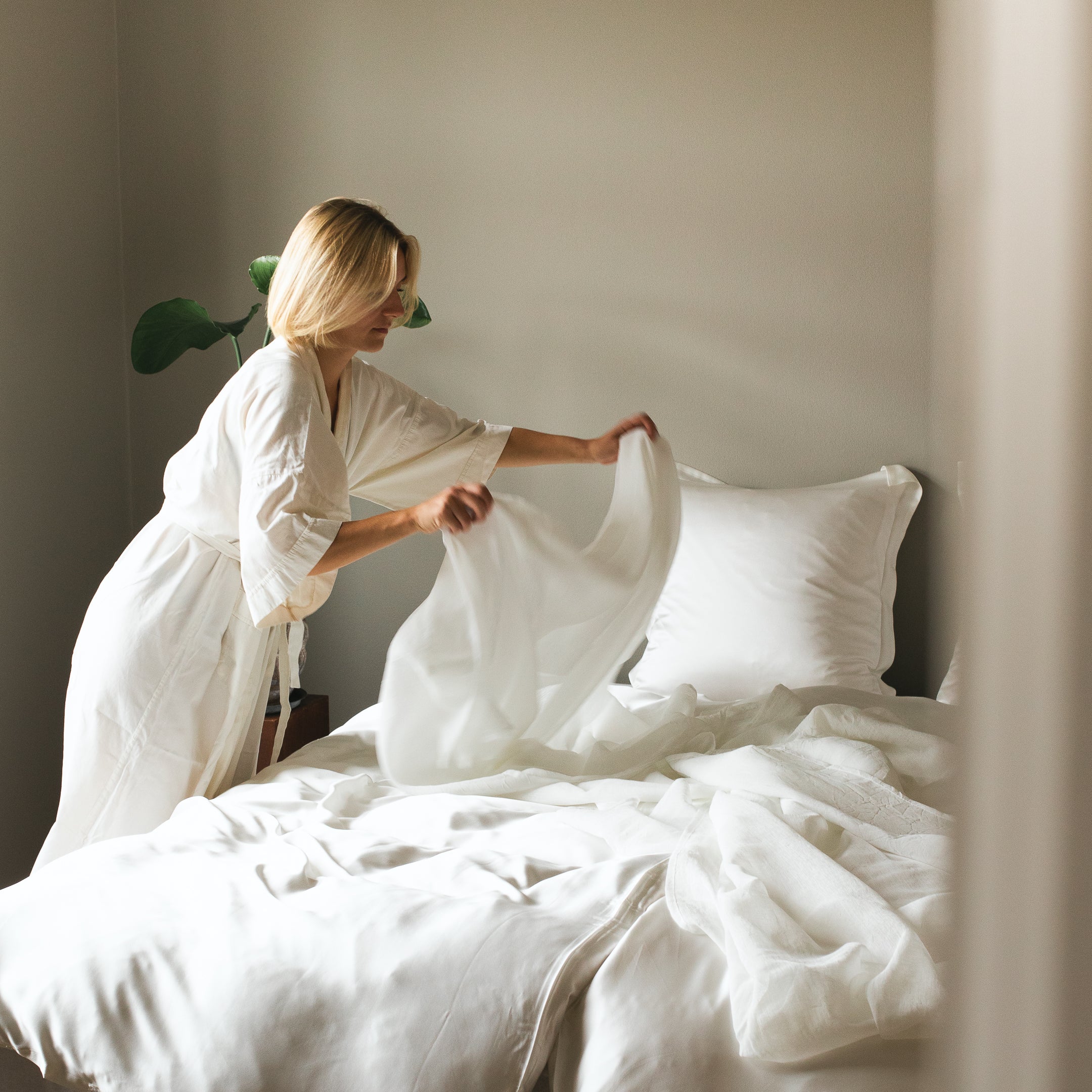 Kvinde reder seng iført bambus kimono