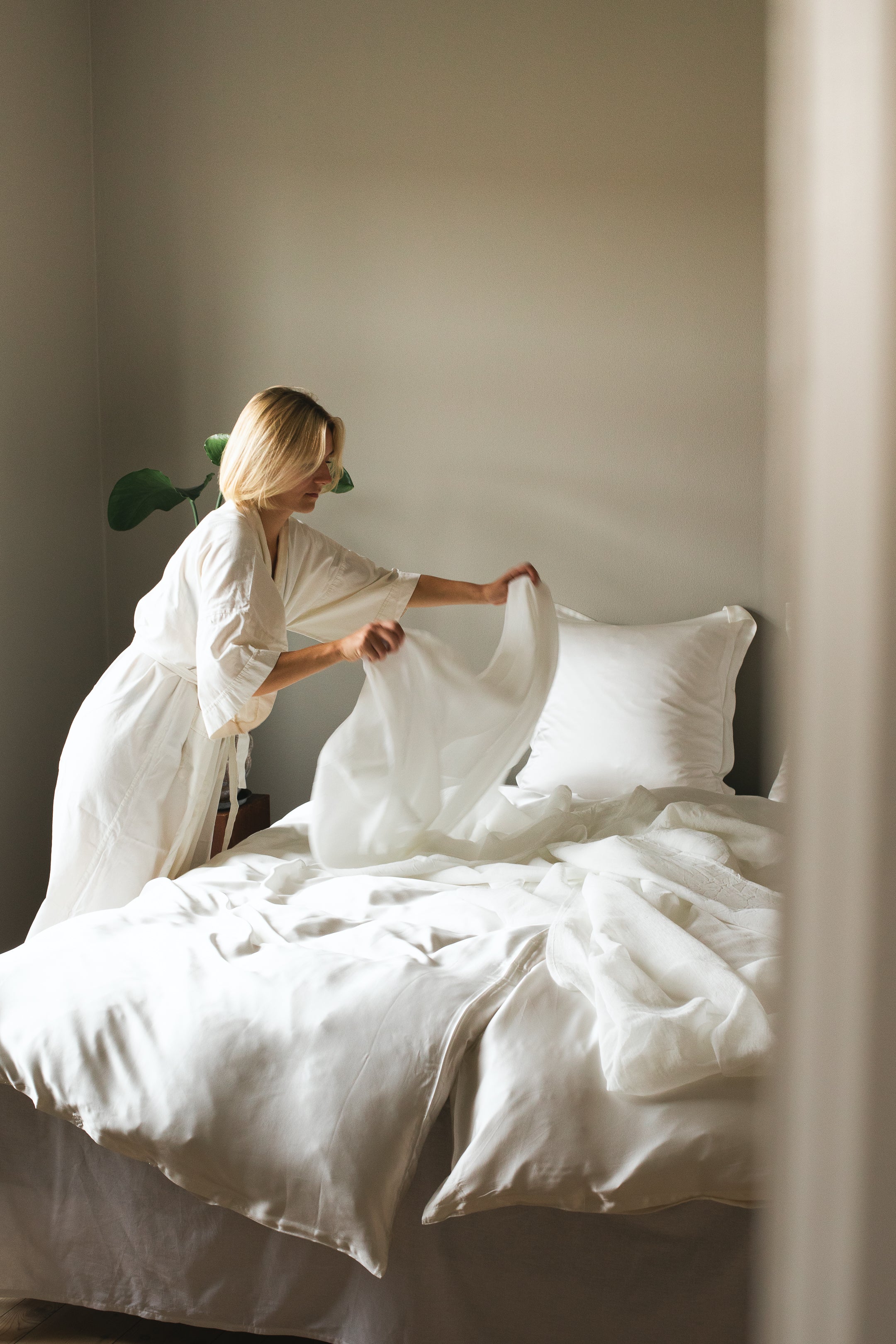 Kvinde reder seng iført bambus kimono