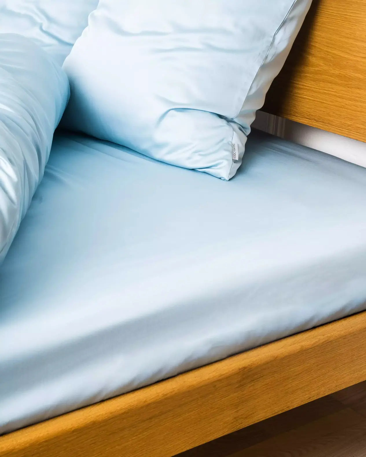 Miljøbillede af seng redt med bambus kuvertlagen i farven lys blå i størrelsen 140x200x20cm