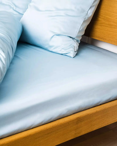 Miljøbillede af seng redt med bambus kuvertlagen i farven lys blå i størrelsen 160x200x20cm