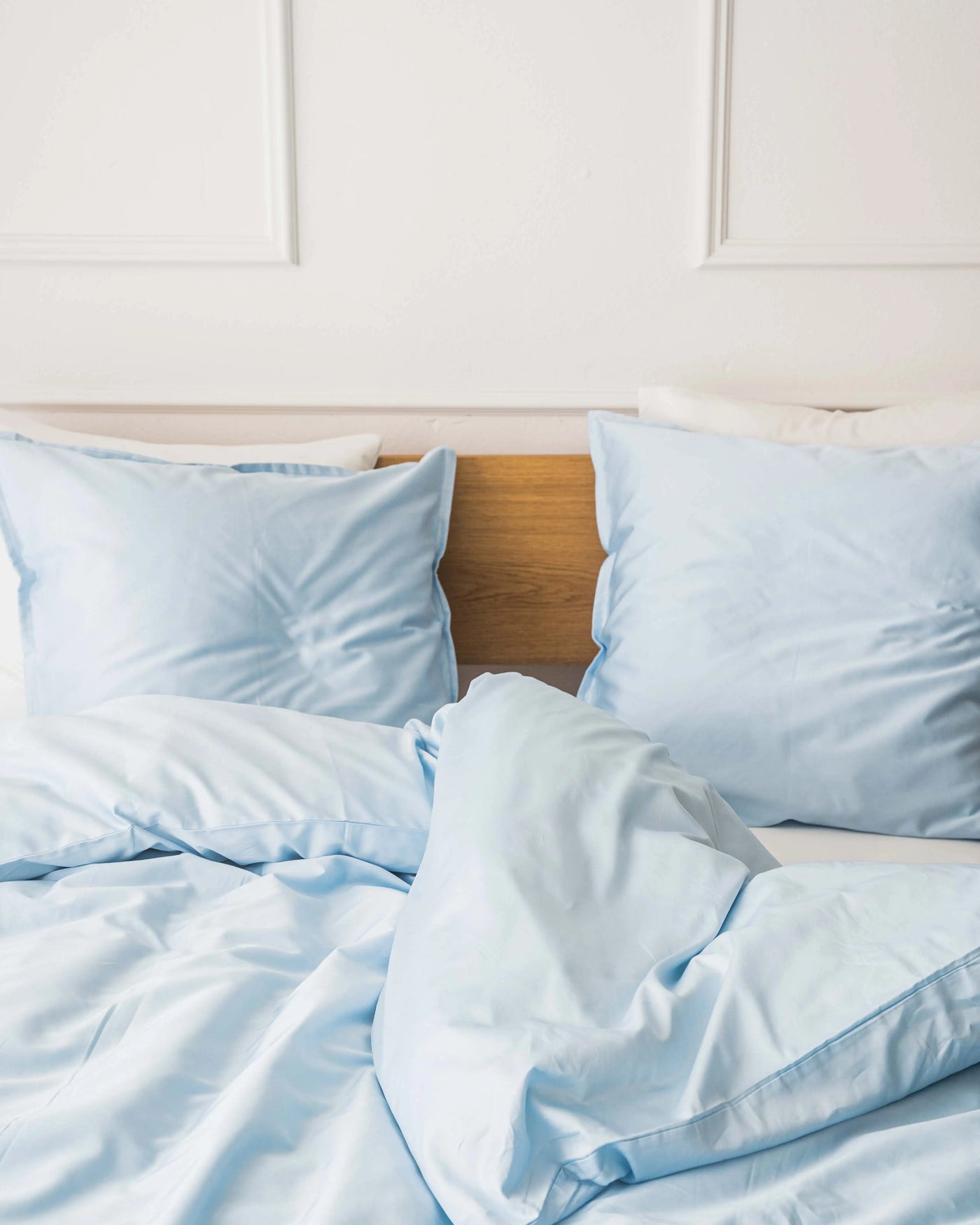 Miljøbillede af redt seng med egyptisk bomuld i farven lys blå